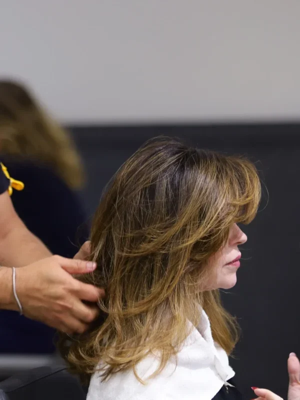 Profissional apresenta cabelo médio com corte em camadas, mechas e finalização modelada